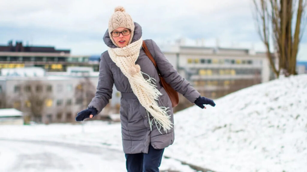 Girl walking carefully on icy road.