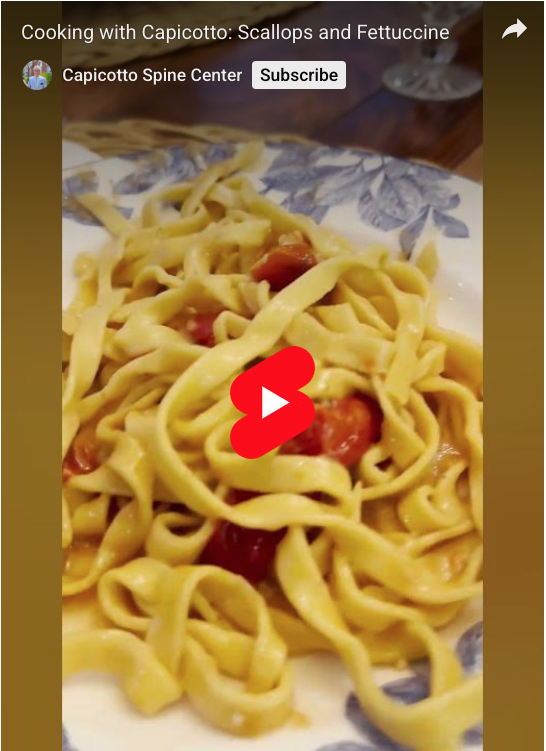 A close up shot of fettuccine paste with tomatoes.