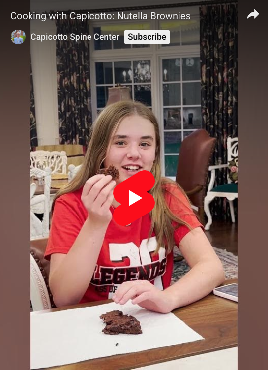 A girl in a red t-shirt eating nutella brownies.