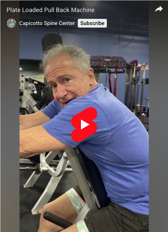 William Capicotto demonstrating how to use a plate loaded pull back machine.